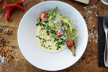 Vegan warm asparagus-broccoli salad with dill aioli, vegan cheese. Delicious healthy vegeterian food served for lunch on a table in modern gourmet cuisine restaurant