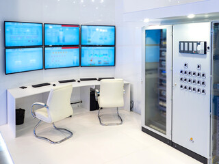 Dispatch center of enterprise. Desk for dispatchers. Several monitors above table. Load monitoring...