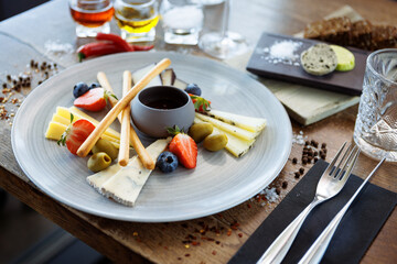 Cheese platter for two: Goat cheese cream, gorgonzola, camembert, grissini and fig jam. Delicious healthy Italian traditional food closeup served for lunch in modern gourmet cuisine restaurant