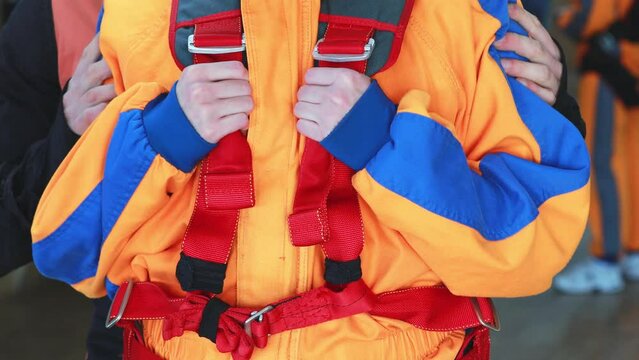 Practicing instructor checks the equipment before the tandem jump, tightens the straps