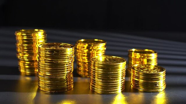 Closeup of shining golden coins on dark background - concept of wealth