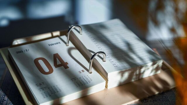 Close-up time-lapse view of a calendar notebook with flipping pages