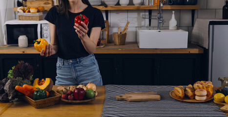 Happy two young women looking laptop computer during cooking together in kitchen room at home. Two young diverse lesbian women spending time together. LGBT and gender identity concept