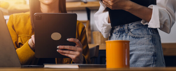 Cropped photo of Freelancer business Asian woman holding coffee cup and at doing planning analyzing the financial report, business plan investment, finance analysis the workplace.