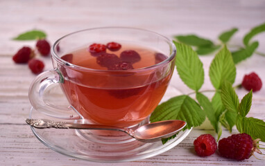 Raspberry tea in a glass cup on a berm background.Close-up.
