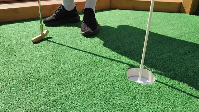 Summer hobbies. unrecognizable person playing mini golf
