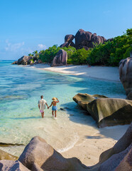 a young couple of men and women on a tropical beach during a luxury vacation in Seychelles. Tropical beach Anse Source d'Argent, La Digue Seychelles