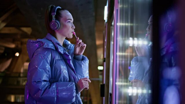 Girl looking vending machine making choice closeup. Woman buying snack at subway