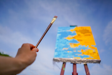 A close-up of an oil painting standing on an easel against the sky the concept of love of fine art 