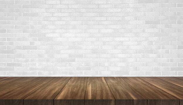 empty wood table with white brick wall background for product placement. brown wooden table at foreground in bright room. rustic wooden table with light from above.