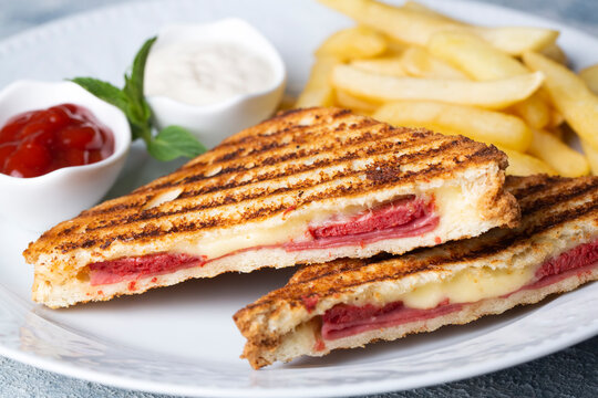 Turkish toast, mixed toast with cheddar cheese, sausage and ham, with fried potatoes (Turkish name; Karisik tost)