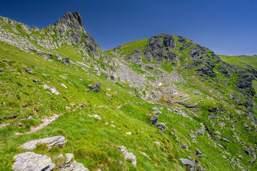 Summer landscape of the Fagaras Mountains. View from the hiking trail from Lake Balea to Mount Negoiu. Amazing rock formations of the Carpathians, Romania.