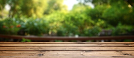 Fototapeta premium The wooden table is empty with a blurry outdoor garden background. It is a blank space for marketing promotion, with space for text.