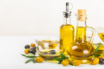 Olive oil in a bottle and gravy boat on the kitchen table. Oil bottle with branches and fruits of olives. Place for text. copy space. vegetable oil and salad dressing.