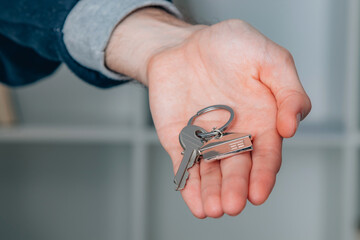 hand with keychain and house key