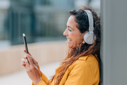 middle-aged woman with mobile phone and headphones