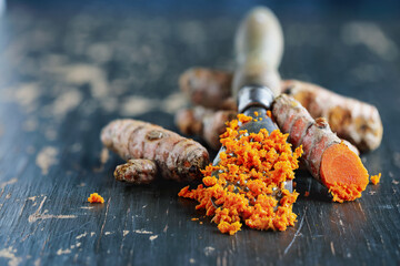 Freshly ground turmeric root containing curcumin, an anti-inflammatory and antioxidant substance. Selective focus with blurred background and fore