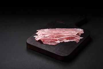 Fresh raw bacon cut into slices with salt, spices and herbs