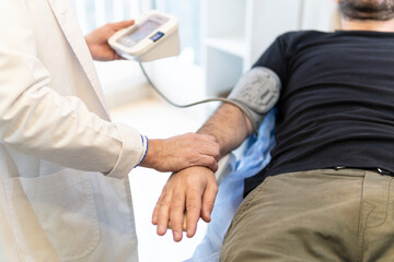 Obraz premium Doctor taking patient's blood pressure