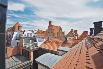 Roofs and brick buildings in the old town of Torun in Poland. The view from the terrace in sunny summer day. - 630853999