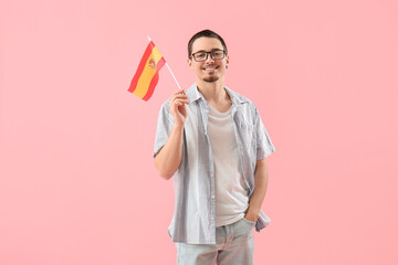 Handsome young man with flag of Spain on pink background - obrazy, fototapety, plakaty