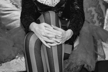 Close up of show theatrical lady legs. Crop black white photo of circus performers woman sits in...