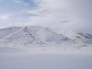 Fototapeta na wymiar Arctic landscape of white snowy hills on Svalbard, Norway