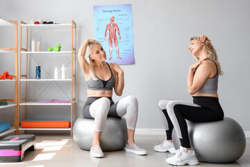 Young woman with physiotherapist doing face building exercise in rehabilitation center