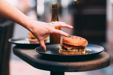 Person grabbing burger with a hand - 630864335