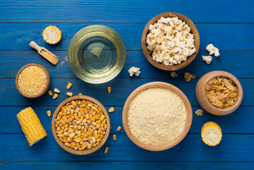 Maize products with fresh corn cobs on wooden background, top view