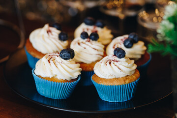 tasty cupcakes with cream on a black dish