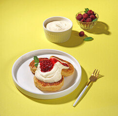 Homemade cottage cheese pancakes with berries on a yellow background in hard light. View from above.