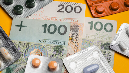 warsaw, poland - 31 07 2023: Polish PLN banknotes lying on a yellow background surrounded by pills and medicines (selective focus)