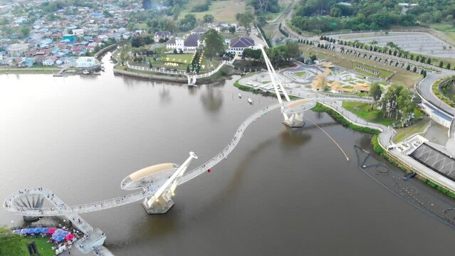 Beautiful aerial view of Darul Hana Bridge over Sungai nearby greenery and houses