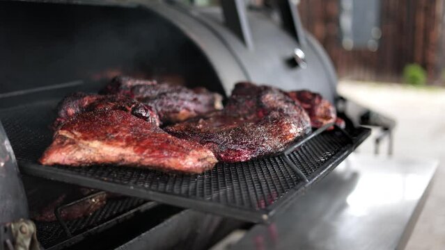 Male hand cooked beef steak meat piece outdoor grill barbecue sprinkling liquid oil sauce slowmo