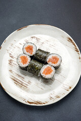 Delicious roll with salmon, Japanese cuisine. Black background. Close up 