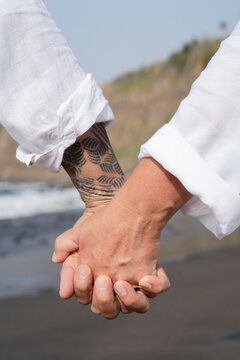 lifestyle with caucasian senior couple resting on beach, holding hands close up, happy in love romantic and relax time, tourism of elderly family pleople, leisure and activity travel after retirement