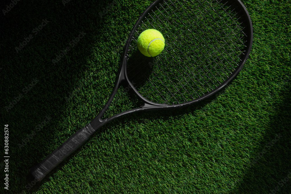 Wall mural top view of tennis rackets and ball of green grass. horizontal sport poster, greeting cards, headers