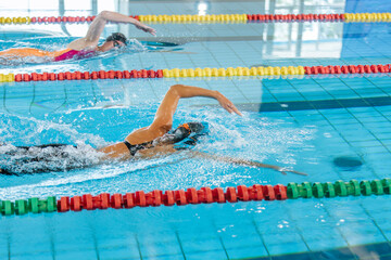Two female swimmers during a race in the freestyle swim discipline. Concept of front crawl stroke...