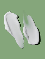 Cosmetic smear of cream texture on a green background. Skin care.
