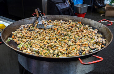 Large metal pan with heap of fresh frying clams cooking. Seafood. Delicious snack for gourmands