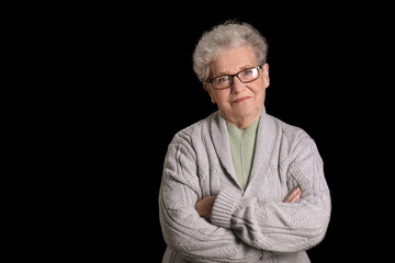 Senior woman in eyeglasses on black background