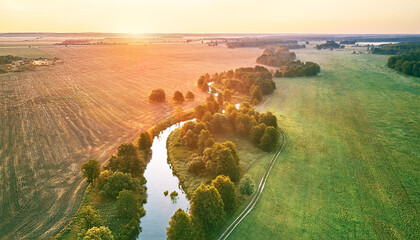 Aerial summer sunrise view. Rural landscape, river meandering in forest green trees. Morning Misty Scene. Serene atmosphere fog panorama. Agriculture fields, wood on riverbank. - 630901365
