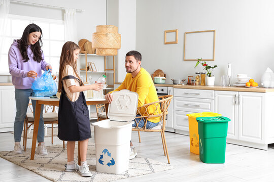 Family sorting plastic garbage with recycle bin in kitchen