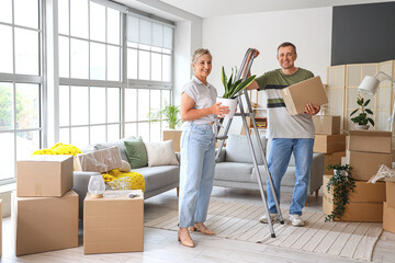 Mature couple packing things in room on moving day