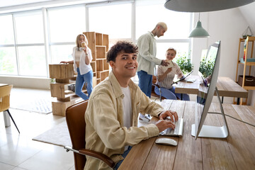 Obraz premium Male graphic designer working with computer at table in office