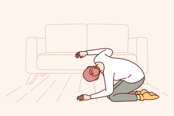 Woman looks under sofa in living room in search of lost wallet with money or missing keys. Confused girl in casual clothes bends down and seeks for TV remote control that fell under sofa