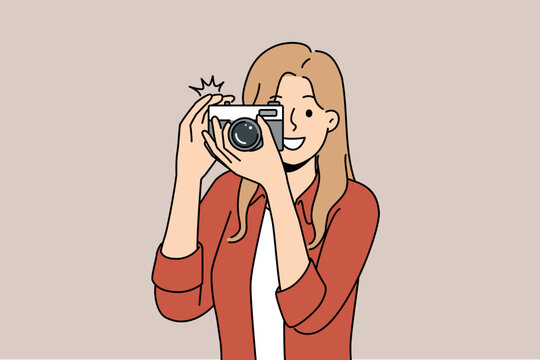 Woman with camera with smile takes photo for publication in newspaper or on pages of personal internet blog. Young happy girl uses camera to capture picturesque locations while traveling