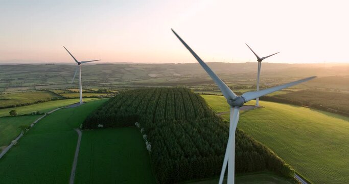 Three windmills stand at sunset 4k