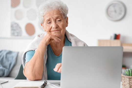 Senior woman using laptop at home